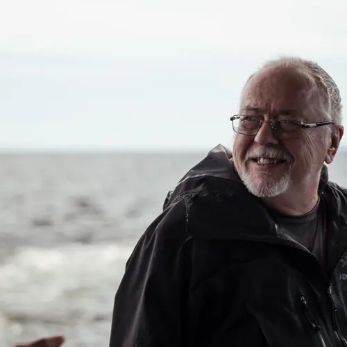 Senior man enjoying the view of wavy waterbody / Homme âgé profitant de la vue sur un plan d'eau ondulé